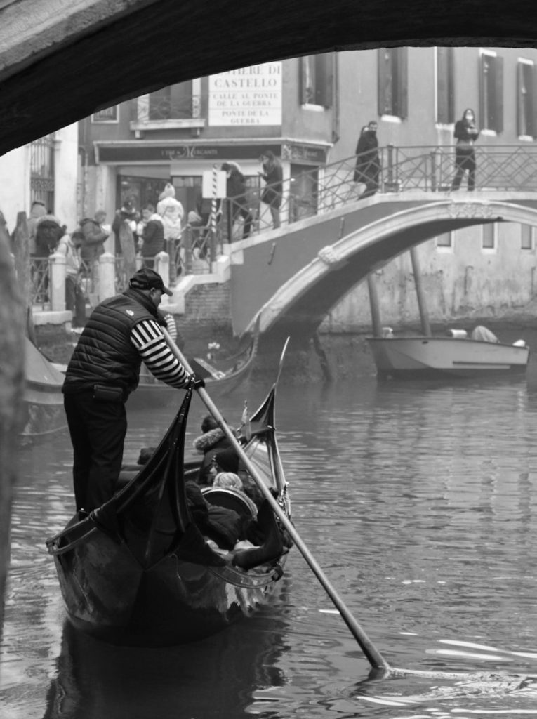 Un gondoliere a Venezia con una gondola asimmetrica
